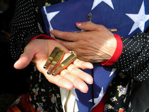 folded funeral flag along with three shell casings